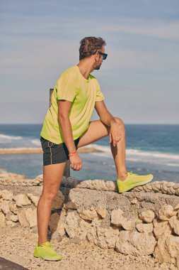 Okyanus yakınında tropikal egzotik uçurumun üzerinde uzanan Sportsman.