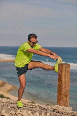 Okyanus yakınında tropikal egzotik uçurumun üzerinde uzanan Sportsman.
