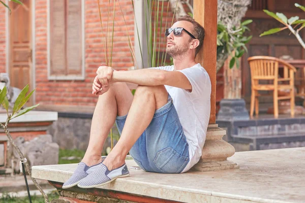 Man zittend op een huis patio/veranda en genieten van de zomer. — Stockfoto