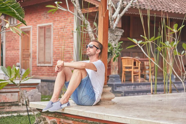 Man zittend op een huis patio/veranda en genieten van de zomer. — Stockfoto