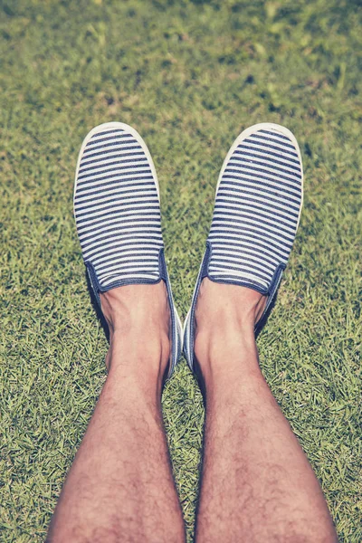 Homem de sapatos listrados na grama . — Fotografia de Stock