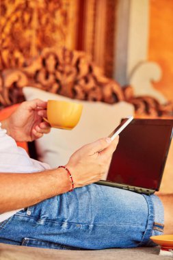 Bir ev verandada kahve / çay ve dizüstü bilgisayar ile Man.