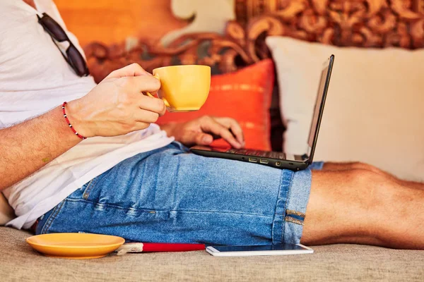 Hombre con café / té y portátil en un porche de casa . — Foto de Stock