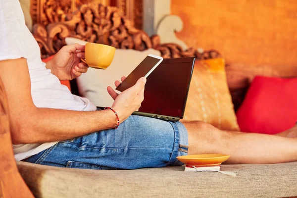 Hombre con café / té y portátil en un porche de casa . — Foto de Stock