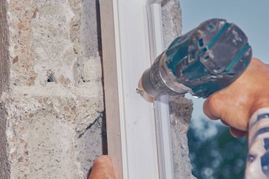 Pvc pencere fra içine vida için pil el matkap kullanarak Işçi