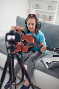 İnternet vlog web sitesi dersleri için video dersleri ve özel ders hazırlayan çocuk gitarist.
