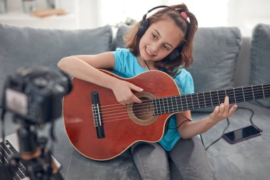 İnternet vlog web sitesi dersleri için video dersleri ve özel ders hazırlayan çocuk gitarist.