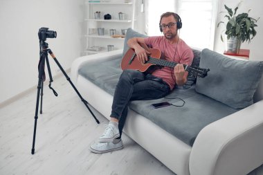 İnternet vlog web sitesi dersleri için video dersleri ve dersler hazırlayan gitarist.