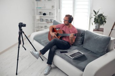 İnternet vlog web sitesi dersleri için video dersleri ve dersler hazırlayan gitarist.