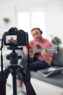 İnternet vlog web sitesi dersleri için video dersleri ve dersler hazırlayan gitarist.