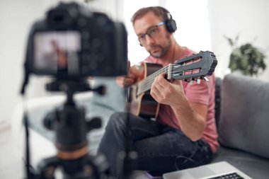 İnternet vlog web sitesi dersleri için video dersleri ve dersler hazırlayan gitarist.