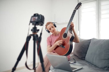 İnternet vlog web sitesi dersleri için video dersleri ve dersler hazırlayan gitarist.
