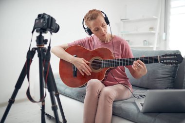 İnternet vlog web sitesi dersleri için video dersleri ve dersler hazırlayan gitarist.