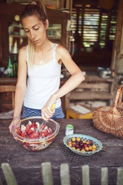 Kadın yaz yemeği için kırsal kesimdeki kır evinde yemek ve ziyafet hazırlıyor..