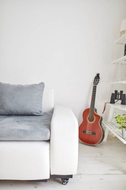 Oturma odasında akustik gitar ve beyaz döşeme..