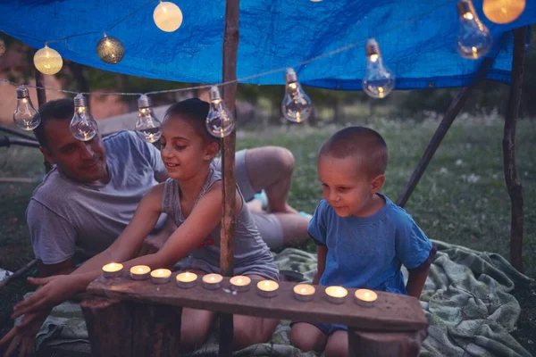 孩子们的父亲在后院用蜡烛和灯笼做了一个小帐篷 — 图库照片