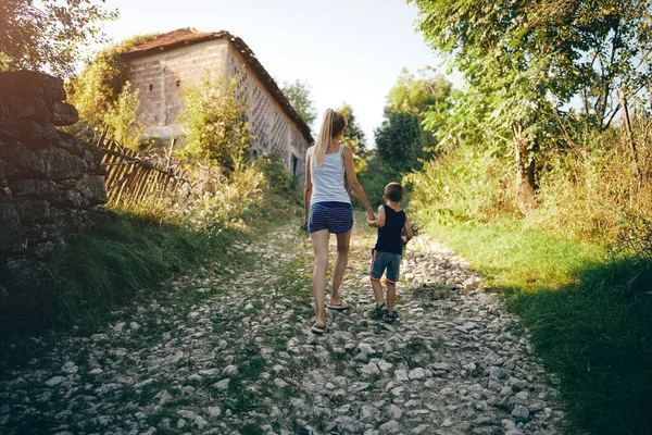 Mutter Und Sohn Mit Blumensträußen Auf Einer Dorfstraße Und Händchen — Stockfoto