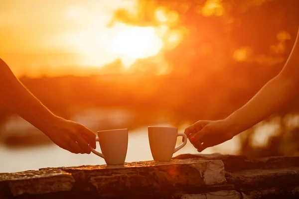 Friends drinking coffee in sunrise time, early morning.