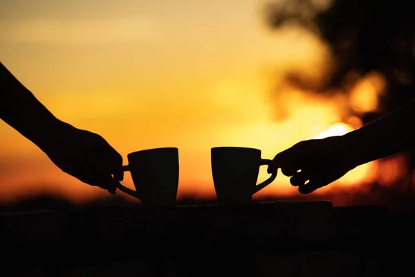 Friends drinking coffee in sunrise time, early morning.