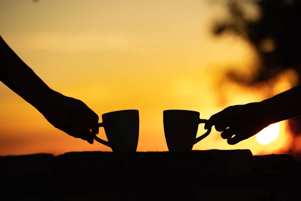 Friends drinking coffee in sunrise time, early morning.