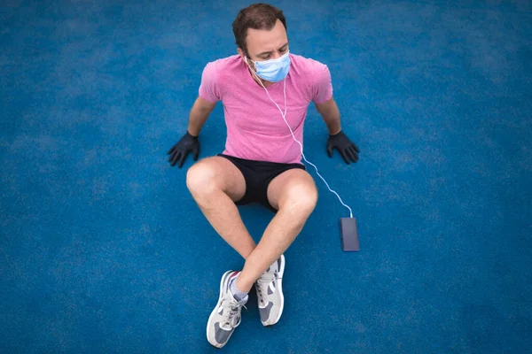 Sportowiec Maską Medyczną Rękawiczkami Smartfon Słuchawki Ćwiczące Jogging Środowisku Miejskim — Zdjęcie stockowe