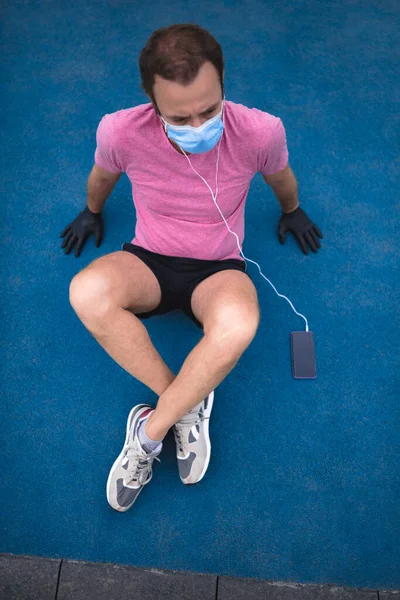 Sportman Met Medisch Masker Handschoenen Smartphone Oordopjes Aan Het Trainen — Stockfoto