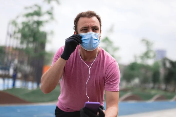 Sportman Met Medisch Masker Handschoenen Smartphone Oordopjes Aan Het Trainen — Stockfoto