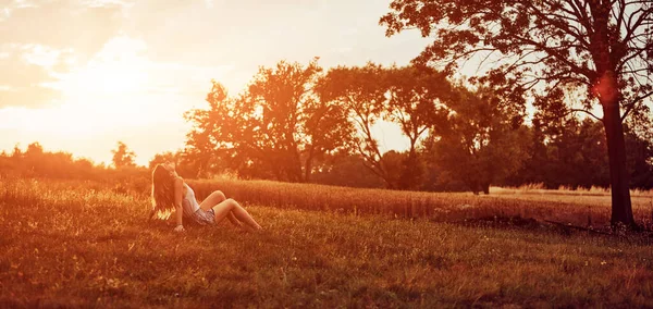 Tarlada oturan bir kadının silueti..