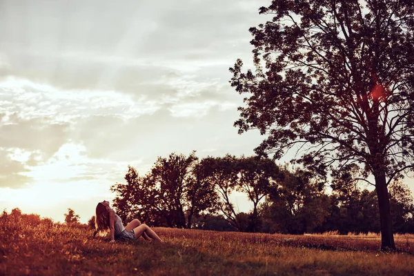 Tarlada oturan bir kadının silueti..