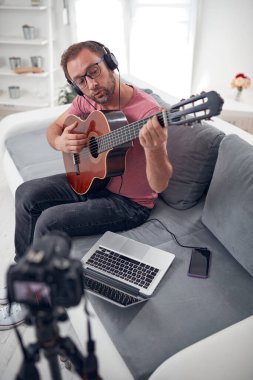İnternet vlog web sitesi dersleri için video dersleri ve dersler hazırlayan gitarist.
