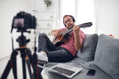 İnternet vlog web sitesi dersleri için video dersleri ve dersler hazırlayan gitarist.