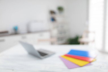 Not defterli, renkli klasörlü, masa ve sandalyeli beyaz oda. Arkaplan için kasıtlı olarak bulanık fotoğraf.