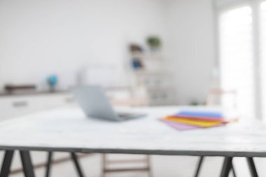 Not defterli, renkli klasörlü, masa ve sandalyeli beyaz oda. Arkaplan için kasıtlı olarak bulanık fotoğraf.