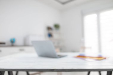 Not defterli, renkli klasörlü, masa ve sandalyeli beyaz oda. Arkaplan için kasıtlı olarak bulanık fotoğraf.