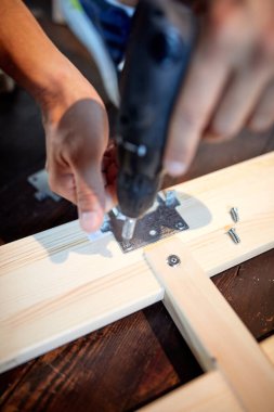 Marangoz meraklısı ev / garajda tahta montajı yapıyor..