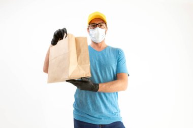Koruyucu maskeli teslimatçı. Elinde poşet dolusu yiyecek var..