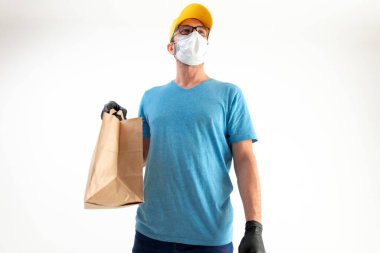 Koruyucu maskeli teslimatçı. Elinde poşet dolusu yiyecek var..