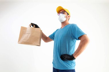 Koruyucu maskeli teslimatçı. Elinde poşet dolusu yiyecek var..