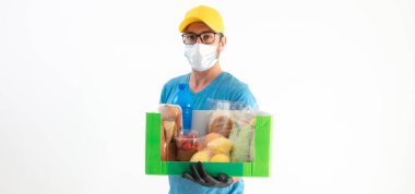 Koruyucu maskeli teslimatçı. Bakkaliye kutusuyla birlikte..