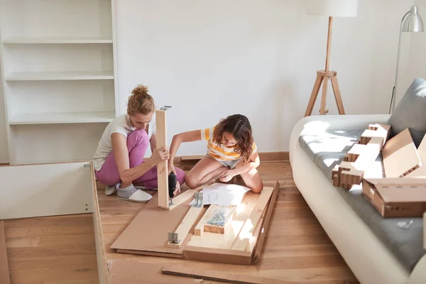 母亲和女儿在新公寓里组装家具 搬进来努力工作 — 图库照片