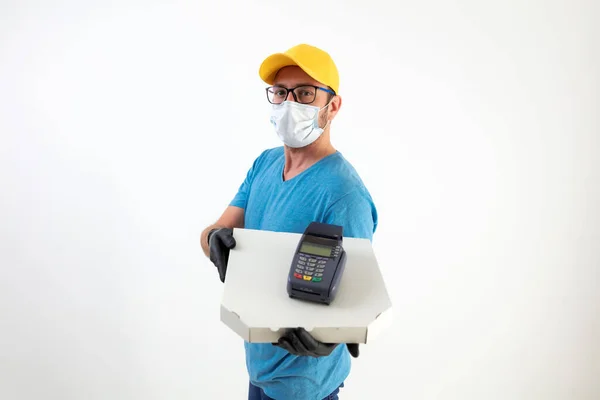 Delivery guy with protective mask holding pizza box and POS for contactless payment.