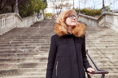 Büyük bir merdivende tek başına oturan tatlı gülen kız..