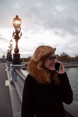 Paris geçmişi olan cep telefonu kullanan bir kız, Seine Nehri..