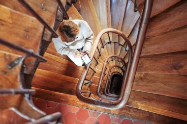 Binanın merdivenlerinde cep telefonu kullanan bir kadın..