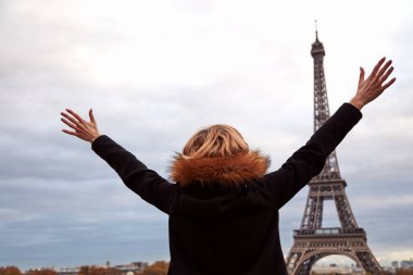 Eiffel Kulesi önünde kolları açık bir kadın, Paris, Fransa.