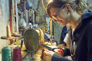 Evde retro dikiş makinesi kullanan bir kadın terzi, hobi konsepti..