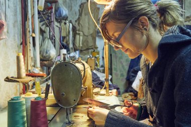 Evde retro dikiş makinesi kullanan bir kadın terzi, hobi konsepti..