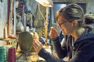 Evde retro dikiş makinesi kullanan bir kadın terzi, hobi konsepti..