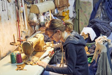 Evde retro dikiş makinesi kullanan bir kadın terzi, hobi konsepti..