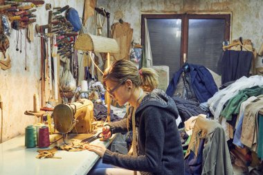 Evde retro dikiş makinesi kullanan bir kadın terzi, hobi konsepti..